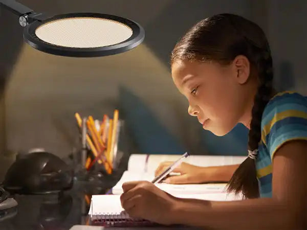 A desk lamp illuminating a student doing homework.