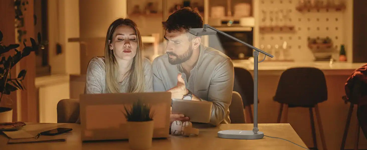 Two people working together at a laptop in warm lighting.slider_item_YWQGMa